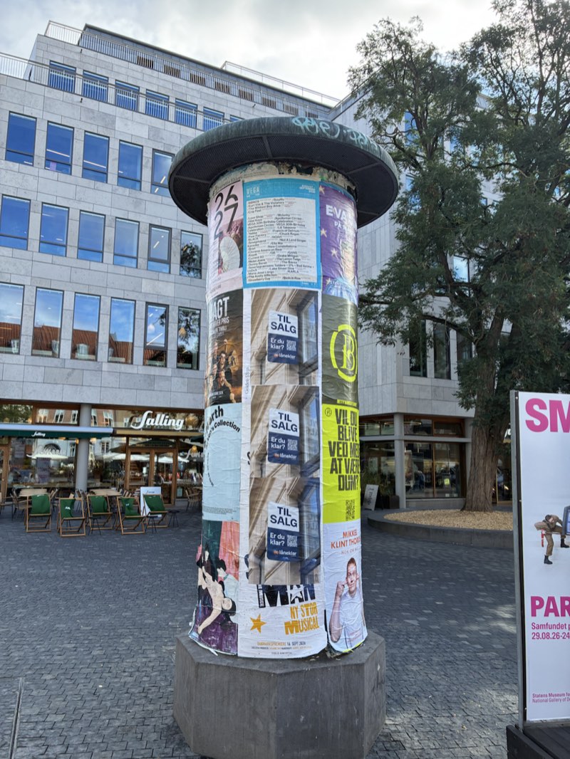 En plakatsøjle på en byplads med Låneklars plakater Til salg. Er du klar?